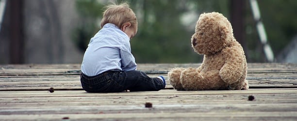 Baby and Toy sitting on wooden floor